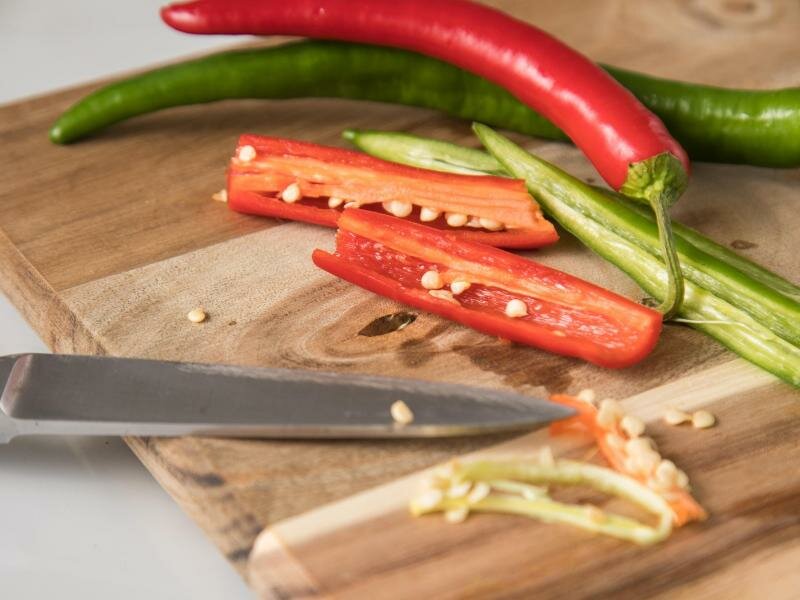 Wie scharf eine Chilischote ist, hängt vom Capsaicin-Gehalt der jeweiligen Sorte ab. Besonders viel von dem Scharfmacher befindet sich in den weißen Rippen, an denen die Kerne hängen. Foto: Christin Klose/dpa-tmn