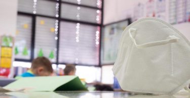 Eine FFP2-Maske liegt in einer Grundschule auf einem Tisch. In zwei Bundesländern greifen ab Montag Lockerungen bei der Maskenpflicht an Schulen. Foto: Sebastian Gollnow/dpa