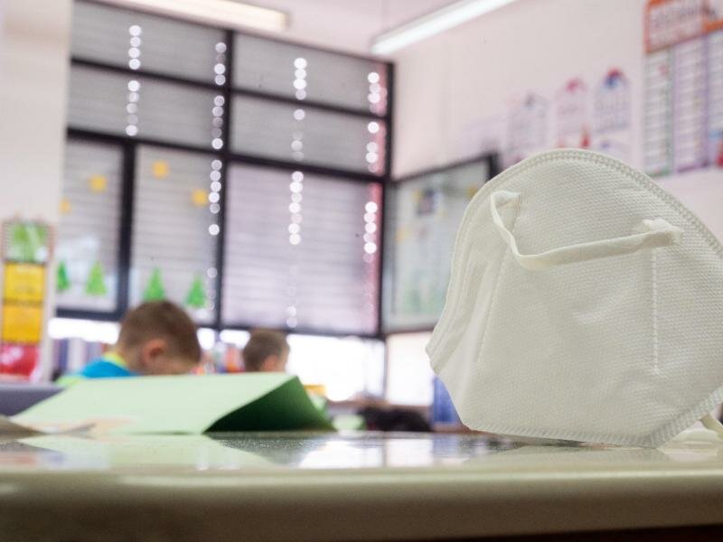 Eine FFP2-Maske liegt in einer Grundschule auf einem Tisch. In zwei Bundesländern greifen ab Montag Lockerungen bei der Maskenpflicht an Schulen. Foto: Sebastian Gollnow/dpa