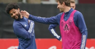 Thomas Müller (r) schertzt im Training mit Serge Gnabry. Foto: Marcus Brandt/dpa
