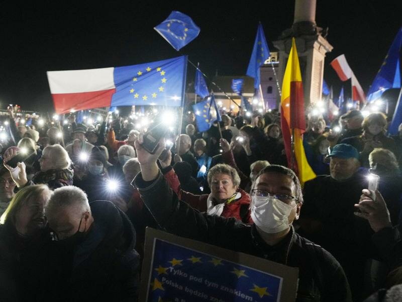 Menschen halten während einer Demonstration in Warschau die Taschenlampen ihrer Mobiltelefone hoch. Foto: Czarek Sokolowski/AP/dpa