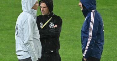 Oliver Bierhoff (l-r), Direktor Nationalmannschaften und Akademie, spricht mit Joshua Kimmich und Leon Goretzka vor dem Spiel auf dem Rasen. Foto: Federico Gambarini/dpa