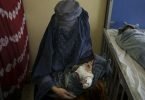Eine Frau hält eines ihrer beiden Babys, die in Kabul behandelt werden, auf dem Arm. Foto: Felipe Dana/AP/dpa