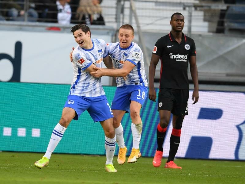 Herthas Torschütze Jürgen Ekkelenkamp (l-r) und Santiago Ascacibar jubeln nach dem Tor zum 2:0 neben Frankfurts Evan Ndicka. Foto: Arne Dedert/dpa