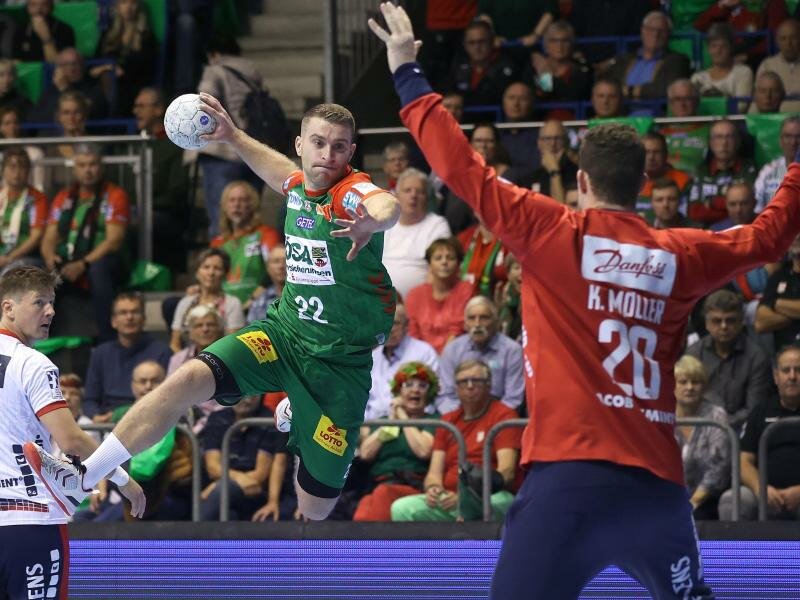 Magdeburgs Lukas Mertens (M) steigt gegen Flensburgs Torwart Kevin Moeller zum Sprungwurf hoch. Foto: Ronny Hartmann/dpa