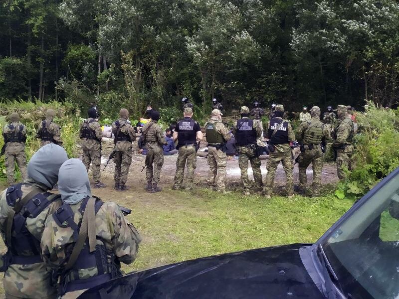 Migranten werden nach dem Grenzübertritt von Belarus nach Polen im Dorf Usnarz Gorny festgehalten. (Archivbild). Foto: Mateusz Wodziński/AP/dpa