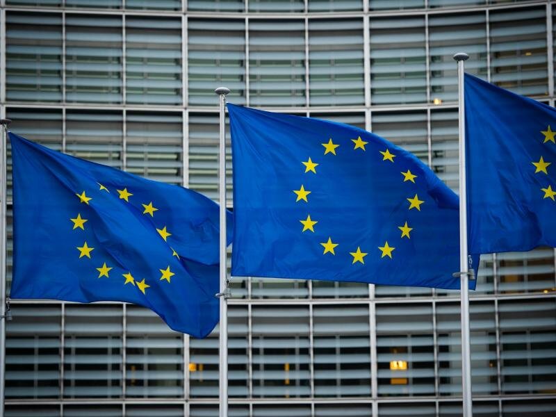 Flaggen der Europäischen Union wehen im Wind vor dem Berlaymont-Gebäude in Brüssel. Die EU-Kommission will die Haushaltsregeln für Mitgliedstaatn nach der Aufnahme von Rekordschulden in der Corona-Pandemie vereinfachen. Foto: Arne Immanuel Bänsch/dpa