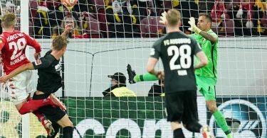 Mainz' Stürmer Jonathan Burkhardt (l) köpft den Ball zum 3:0 ins Tor von Augsburgs Torwart Rafal Gikiewicz (r). Foto: Uwe Anspach/dpa
