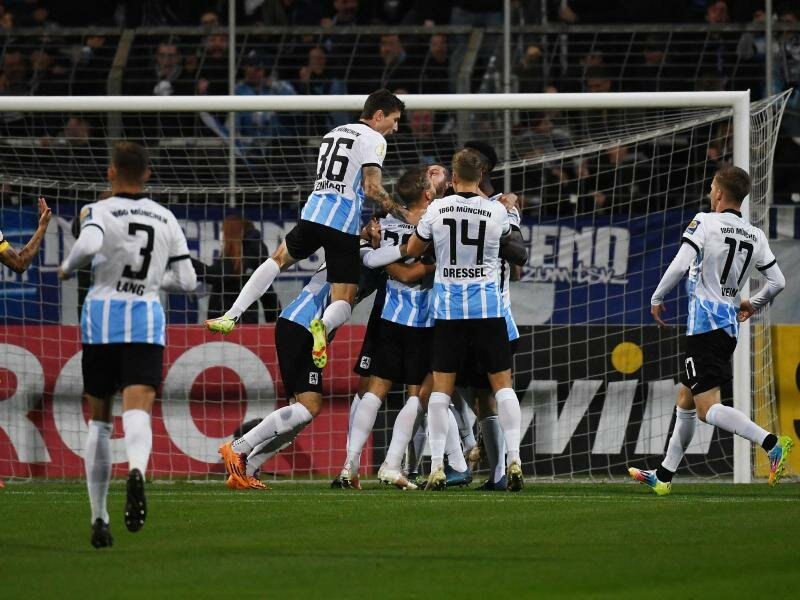 Die 1860-Spieler feiern den Sieg gegen den FC Schalke 04. Foto: Angelika Warmuth/dpa