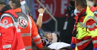 Der Nürnberger Tom Krauß (M) wird verletzt aus dem Stadion getragen, zeigt aber mit dem Daumen nach oben. Foto: Daniel Karmann/dpa