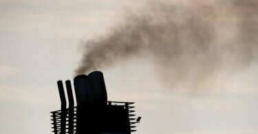 Eine Fähre stößt Abgase aus einem Schornstein aus. An der Klimakrise hat der Schiffsverkehr einen vergleichsweise großen Anteil. Foto: Daniel Reinhardt/dpa