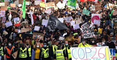 Demonstrierende ziehen mit Flaggen und Schildern durch die Straßen von Glasgow. Foto: Andrew Milligan/PA/dpa