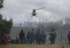 Ein polnischer Militärhubschrauber fliegt über eine Gruppe Migranten, die sich an der weißrussisch-polnischen Grenze versammelt haben. Foto: Leonid Shcheglov/BelTA/AP/dpa