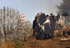 Migranten vor einem Grenzzaun aus Stacheldraht an der belarussisch-polnischen Grenze bei Grodno Grodno. Foto: Leonid Shcheglov/BelTA/AP/dpa