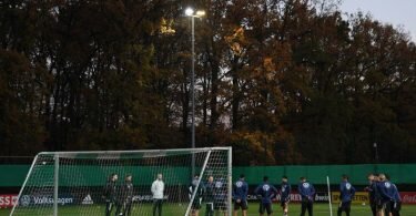 Zum Training hat Bundestrainer Flick die Mannschaft im Halbkreis vor einem Tor versammelt. Foto: Swen Pförtner/dpa
