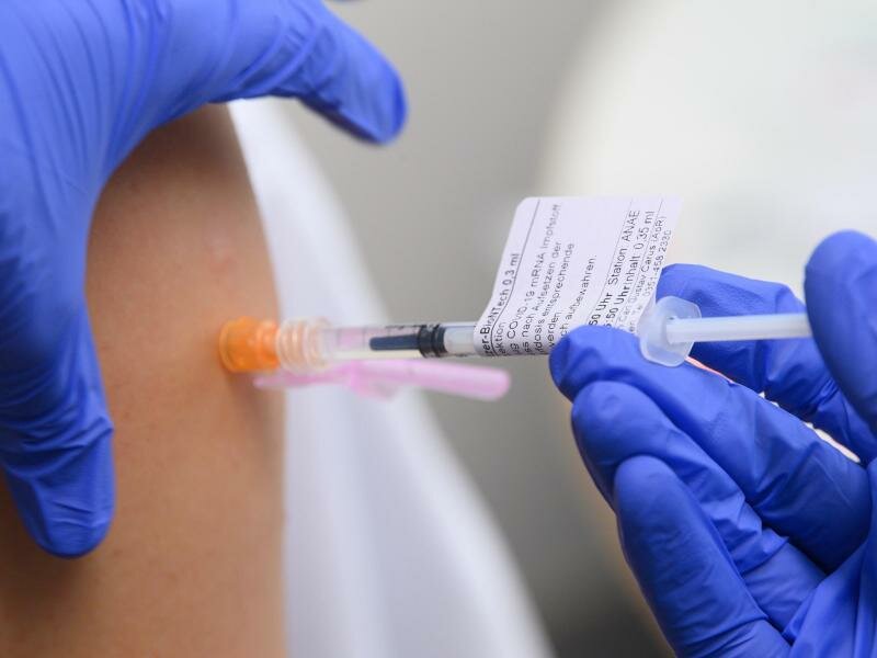 Eine Ärztin impft im Universitätsklinikum in Dresden einen Arztkollegen mit der dritten Impfung gegen das Coronavirus. Foto: Robert Michael/dpa-Zentralbild/dpa