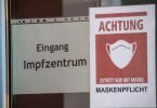 Ein Schild mit dem Schriftzug «Impfzentrum» weist den Weg zu einem Corona-Impfstützpunkt. Foto: Stefan Sauer/dpa