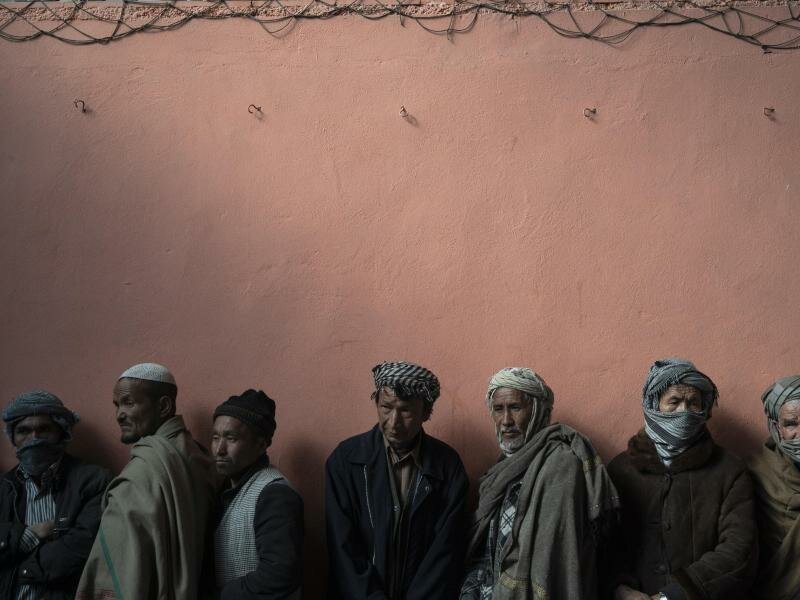 Männer warten in einer Schlange, um bei einer vom Welternährungsprogramm (WFP) organisierten Geldverteilung Bargeld zu erhalten. Foto: Bram Janssen/AP/dpa