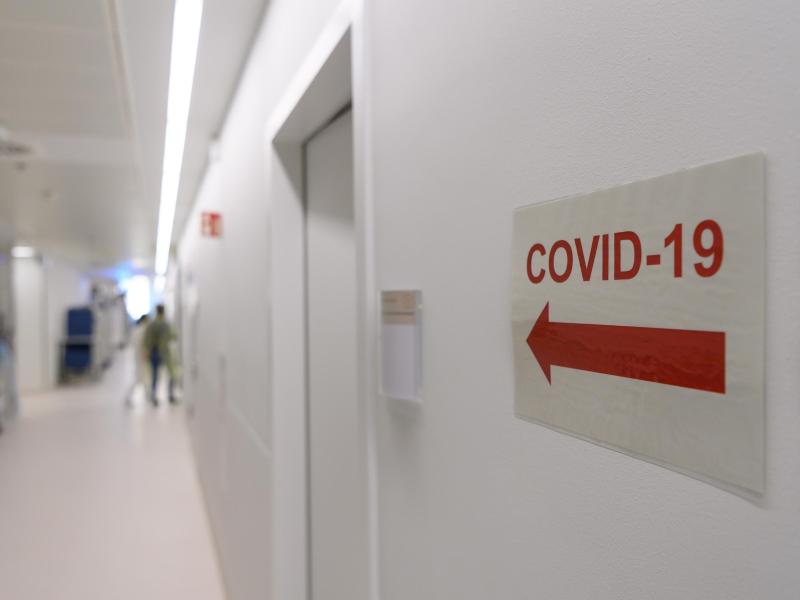 Ein Schild weist in einer Klinik den Weg zur Corona-Intensivstation. Foto: Robert Michael/dpa-Zentralbild/dpa