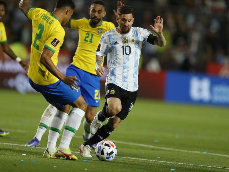 Lionel&nbsp;Messi (r)&nbsp;aus Argentinien in Aktion gegen Matheus Cunha (hinten) und Danilo (l) aus Brasilien. Foto: Gustavo Ortiz/dpa