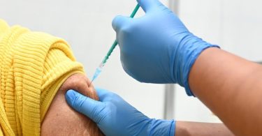Eine Mitarbeiterin vom Impfzentrum am Robert-Bosch-Krankenhaus verabreicht eine Auffrischimpfung gegen das Coronavirus. Foto: Bernd Weißbrod/dpa
