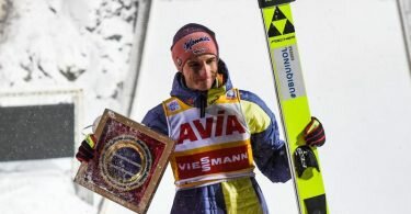 Geiger hält eine Trophäe in der Hand. Er hat sein Gelbes Trikot des&nbsp;Weltcup-Gesamtführenden verteidigt. Foto: Tumaschow/NordicFocus/dpa