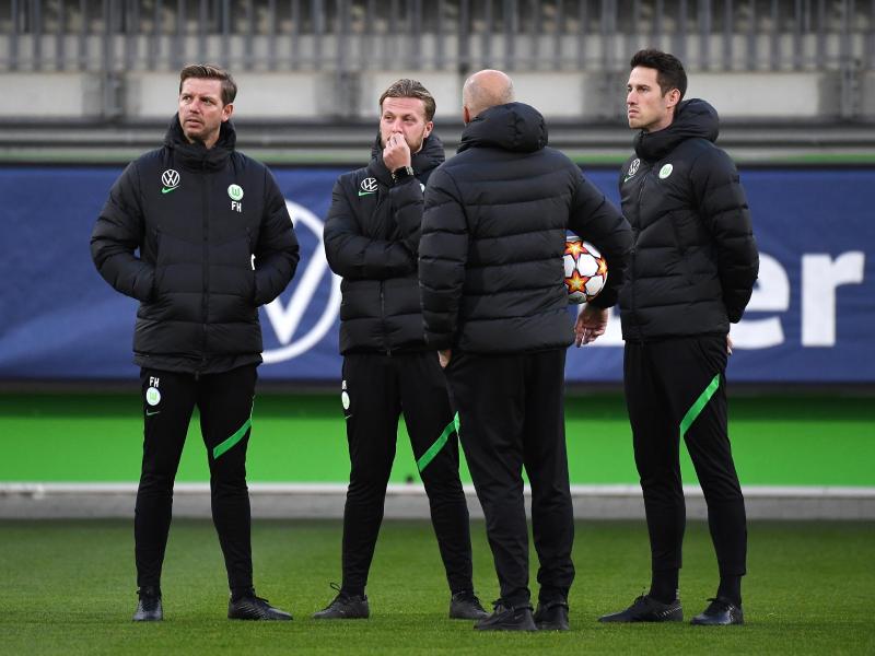 Vor dem Abflug nach Sevilla war Corona wieder ein Thema: Wolfsburgs Trainer Florian Kohfeldt (l) steht mit seinem Team zusammen. Foto: Swen Pförtner/dpa