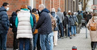 Eine lange Schlange von Impfwilligen wartet vor einem Impfzentrum in Hamburg, um dort das offene Impfangebot wahrzunehmen. Foto: Markus Scholz/dpa