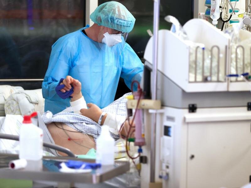 Ein Facharzt versorgt einen Covid-19-Patienten auf der Intensivstation der Leipziger Uniklinik. Foto: Jan Woitas/dpa-Zentralbild/dpa