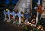 Eine Frau zündet Kerzen an einer Gedenkstätte im Veteran's Park für die Opfer an, nachdem ein Geländewagen am Sonntag in eine Weihnachtsparade gerast war, bei der mehrere Menschen getötet und Dutzende verletzt wurden. Foto: Jeffrey Phelps/AP/dpa