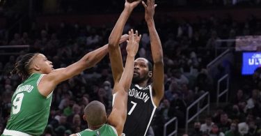 Brooklyn Nets-Forward Kevin Durant (r) wirft, während er von Boston Celtics-Guard Romeo Langford (l) und Forward Jabari Parker verteidigt wird. Foto: Charles Krupa/AP/dpa