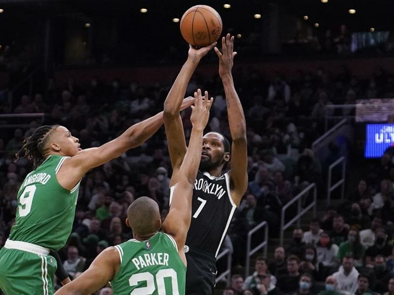 Brooklyn Nets-Forward Kevin Durant (r) wirft, während er von Boston Celtics-Guard Romeo Langford (l) und Forward Jabari Parker verteidigt wird. Foto: Charles Krupa/AP/dpa