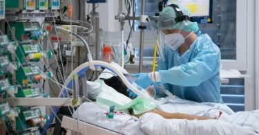 Ein Intensivpfleger kümmert sich um einen Patienten. Foto: Boris Roessler/dpa