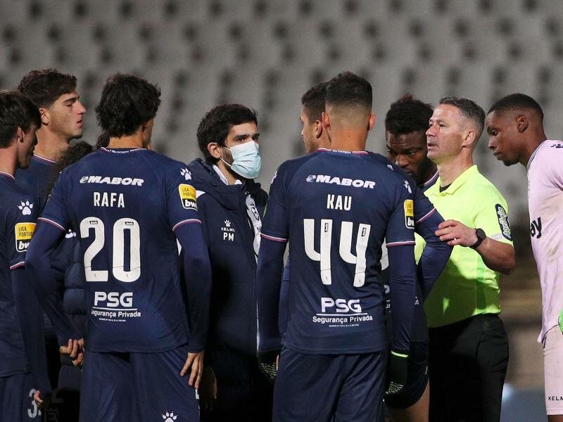 Belenenses hatte gegen Benfica Lissabon wegen der Corona-Fälle nur sechs Spieler zur Verfügung: Schiedsrichter Manuel Mota (2.v.r) diskutiert mit den Spielern. Foto: Sh/Atlantico Press via ZUMA Press/dpa