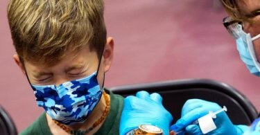 Ein Junge in den USA kneift während seiner Impfung die Augen zusammen. Nun könnte auch die EMA den Impfstoff empfehlen. Foto: Keith Birmingham/The Orange County Register via AP/dpa