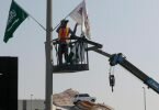 Ein Mitarbeiter hängt Flaggen an der Rennstrecke des Corniche Circuit auf: Die Formel 1 gastiert erstmals in Saudi-Arabien. Foto: Amr Nabil/AP/dpa