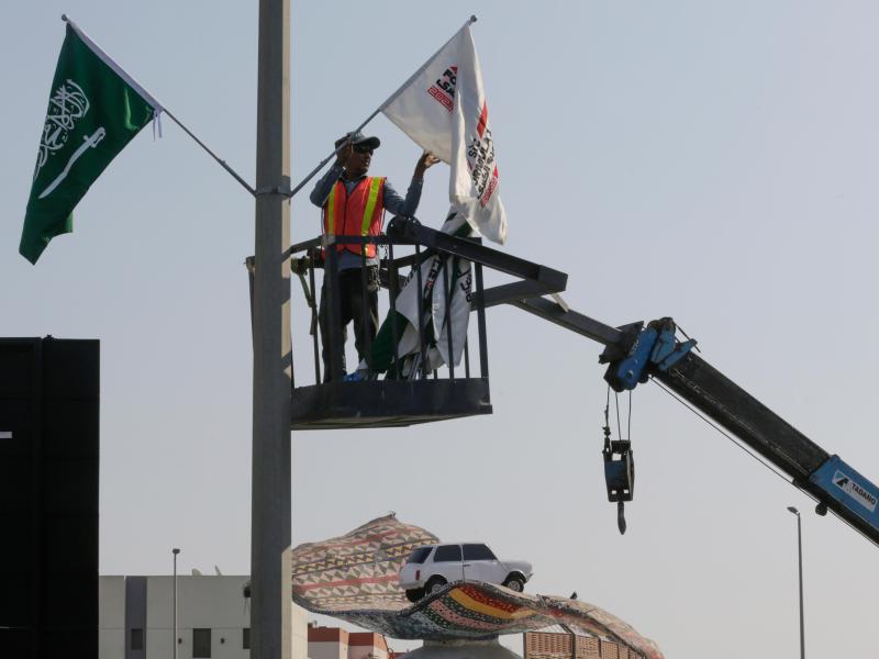 Ein Mitarbeiter hängt Flaggen an der Rennstrecke des Corniche Circuit auf: Die Formel 1 gastiert erstmals in Saudi-Arabien. Foto: Amr Nabil/AP/dpa