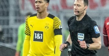 Schiedsrichter Felix Zwayer (M) läuft an Dortmunds Jude Bellingham vorbei, um sich den Videobeweis anzuschauen. Foto: Bernd Thissen/dpa