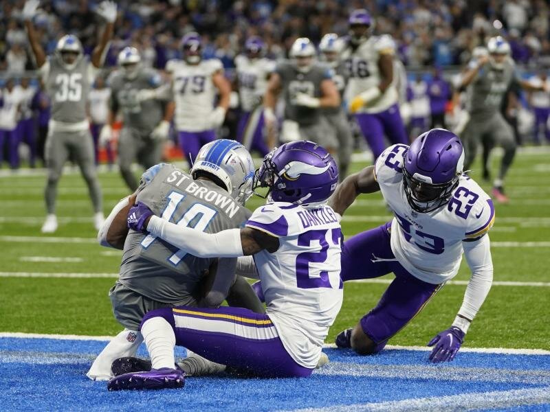 Lions-Receiver Amon-Ra St. Brown (l) fängt den Pass zum spielentscheidenden Touchdown. Foto: Paul Sancya/AP/dpa