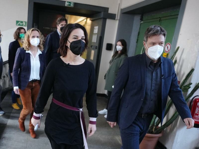 Annalena Baerbock (M), Bundesvorsitzende von Bündnis 90/Die Grünen und Robert Habeck (r), Bundesvorsitzender von Bündnis 90/Die Grünen kommen zur Ergebnisverkündung der Urabstimmung der Grünen-Mitglieder über den Koalitionsvertrag mit SPD und FDP zur Bildung einer Bundesregierung. Foto: Kay Nietfeld/dpa