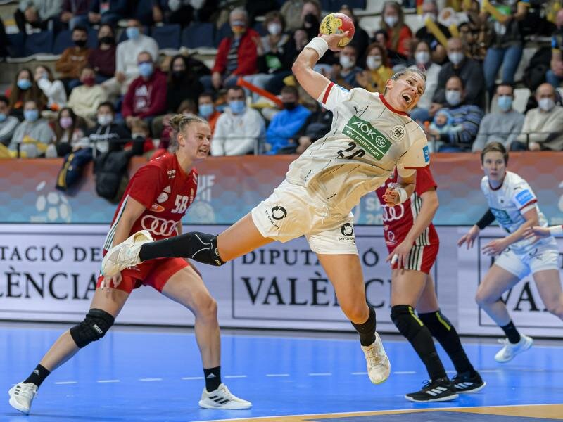 Emily Bölk (M, in weiß)kann sich am Wurfkreis gegen die ungarische Abwehr durchsetzen. Foto: Marco Wolf/dpa