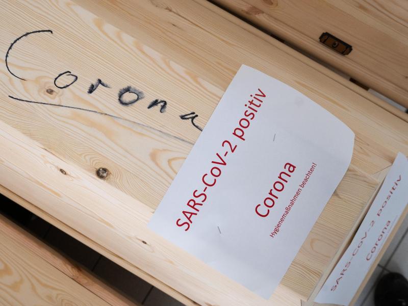 Särge mit Aufschrift „Corona“ und „SARS-CoV-2 positiv - Corona“ mit Verstorbenen in einem Krematorium in Giesen. Foto: Julian Stratenschulte/dpa