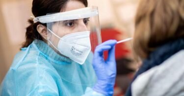 Eine Mitarbeiterin einer Teststation in der Oldenburger Innenstadt nimmt einen Corona-Abstrich von einer Frau. (Archivbild). Foto: Hauke-Christian Dittrich/dpa