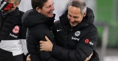 Wolfsburgs Trainer Oliver Glasner (M) und Frankfurts Trainer Adi Hütter (r) begrüßen sich vor einem Spiel. Foto: Swen Pförtner/dpa/Archivbild
