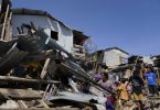 Bewohner suchen in den zerstörten Häusern nach Habseligkeiten. Foto: Jay Labra/AP/dpa