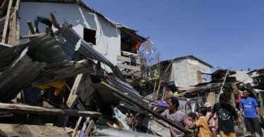 Bewohner suchen in den zerstörten Häusern nach Habseligkeiten. Foto: Jay Labra/AP/dpa