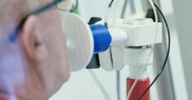 Ein von einer Corona-Erkrankung genesener Patient bekommt in einer Lungentest-Kabine in einer Rehaklinik die Lungenfunktion gemessen. (Archivbild). Foto: Uwe Anspach/dpa