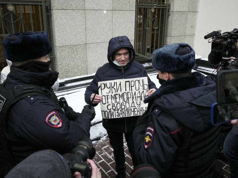 «Hände weg von Memorial, Freiheit für politische Gefangene»:&nbsp;Ein Demonstrant mit einem Protestschild im Beisein von Polizisten vor dem Obersten Gerichtshof in Moskau. Foto: Pavel Golovkin/AP/dpa
