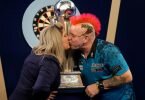 Peter Wright feiert mit seiner Frau Joanne und der Sid Waddell Trophy seinen Sieg. Foto: John Walton/PA Wire/dpa