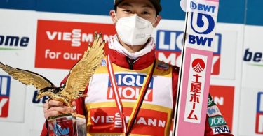 Ryoyu Kobayashi jubelt mit dem Pokal für den Gesamtsieger, einem goldenen Adler, über den Gesamtsieg der Vierschanzentournee. Foto: Daniel Karmann/dpa